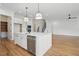 Open-concept kitchen featuring an island with a sink, stainless appliances, and hardwood floors at 3804 Cobbler View Way, Fuquay Varina, NC 27526