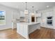 Modern kitchen with white cabinets, quartz countertops, an island and stainless steel appliances at 3804 Cobbler View Way, Fuquay Varina, NC 27526