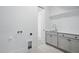 Bright laundry room featuring white cabinets, modern sink and a convenient hanging rack at 3804 Cobbler View Way, Fuquay Varina, NC 27526