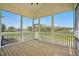 Inviting screened porch with wooden flooring offering scenic views of a lush green field at 3804 Cobbler View Way, Fuquay Varina, NC 27526