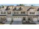 Three-unit townhome building, gray and beige siding, two-car garages at 811 Pryor St, Mebane, NC 27302