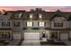 Two-story townhome with gray siding, white garage doors, and a charming front porch at 811 Pryor St, Mebane, NC 27302