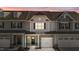 Two-story townhome with gray siding, stone accents, and a two-car garage at 813 Pryor St, Mebane, NC 27302