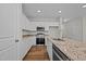 Modern kitchen featuring white cabinets, granite countertops, and stainless steel appliances at 813 Pryor St, Mebane, NC 27302