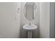 Small powder room with pedestal sink and oval mirror at 813 Pryor St, Mebane, NC 27302