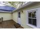 Back deck entrance and window of a home with a blue metal roof and yellow siding at 915 S 3Rd St, Sanford, NC 27330