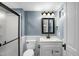 Bathroom features a shower with glass doors, vanity with marble top and vintage mirror at 915 S 3Rd St, Sanford, NC 27330