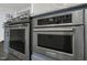 Close up of KitchenAid stainless steel oven and microwave with gray marble countertop and blue cabinets at 915 S 3Rd St, Sanford, NC 27330