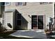 View of the back patio and backyard with beige siding, patio doors, and a small patch of grass at 9507 Dellbrook Ct, Raleigh, NC 27617