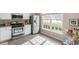 Well-lit kitchen with stainless steel appliances, white cabinets, and large window at 610 Canyon Lake Cir, Morrisville, NC 27560