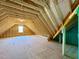 Unfinished attic space with exposed wooden beams and a window at 7553 Sweetwater Dr, Nashville, NC 27856