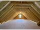Spacious unfinished attic with wooden beams and a window, ready for customization at 7553 Sweetwater Dr, Nashville, NC 27856