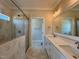 Bathroom features a dual sink vanity with stone countertop, glass-enclosed shower, and tile flooring at 7553 Sweetwater Dr, Nashville, NC 27856