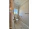 Bathroom features a white toilet and tile floors, with a window for natural light at 7553 Sweetwater Dr, Nashville, NC 27856