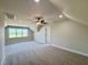 Spacious bonus room featuring plush carpet, neutral paint, ceiling fan, and natural light at 7553 Sweetwater Dr, Nashville, NC 27856