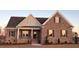 Charming brick home featuring a covered porch, multiple windows, and manicured landscaping at 7553 Sweetwater Dr, Nashville, NC 27856