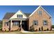 Beautiful brick home with shuttered windows, covered porch and charming architectural details under a bright blue sky at 7553 Sweetwater Dr, Nashville, NC 27856