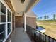 Inviting brick home front porch with black metal railing and concrete floor at 7553 Sweetwater Dr, Nashville, NC 27856