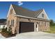 Attached garage with large doors, brick construction, and durable concrete driveway at 7553 Sweetwater Dr, Nashville, NC 27856