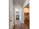 Hallway view to laundry room, bathroom, and closet with wood-look floors and neutral walls at 7553 Sweetwater Dr, Nashville, NC 27856