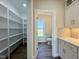 Pantry and bathroom view through the hallway, featuring white cabinets and shelving at 7553 Sweetwater Dr, Nashville, NC 27856