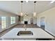 Stylish kitchen island with quartz countertop, modern pendant lights, and gold faucet at 7553 Sweetwater Dr, Nashville, NC 27856