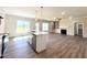 Open-concept living room with kitchen island, stainless steel appliances, and gas fireplace at 7553 Sweetwater Dr, Nashville, NC 27856