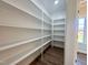 Walk-in pantry with built-in white shelves and wood-look flooring at 7553 Sweetwater Dr, Nashville, NC 27856