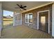 Covered porch with wood flooring, ceiling fan, brick accents, and views of the property's exterior at 7553 Sweetwater Dr, Nashville, NC 27856