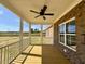 Covered back porch with wood flooring, ceiling fan, brick accents, and views of the backyard at 7553 Sweetwater Dr, Nashville, NC 27856
