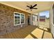 Covered back porch with wood flooring, ceiling fan, brick accents, and access to the backyard at 7553 Sweetwater Dr, Nashville, NC 27856