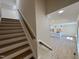 Staircase with wooden stairs leading to the kitchen with white cabinetry and countertops at 7553 Sweetwater Dr, Nashville, NC 27856