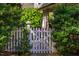 Charming backyard with a white picket fence gate surrounded by lush greenery at 205 N Boundary St, Chapel Hill, NC 27514