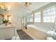 Well-lit bathroom features double windows over a soaking tub and marble countertops at 205 N Boundary St, Chapel Hill, NC 27514