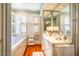 Bright bathroom with double sinks, a soaking tub, and hardwood floors at 205 N Boundary St, Chapel Hill, NC 27514