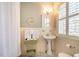 Bright bathroom featuring a pedestal sink, shuttered windows, and fresh, folded white towels at 205 N Boundary St, Chapel Hill, NC 27514