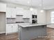 Modern kitchen with white cabinets, gray island, and granite countertops at 317 Highland Ridge Ln, Knightdale, NC 27545