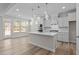 Bright kitchen with a large island, stainless steel appliances, and modern lighting fixtures at 317 Highland Ridge Ln, Knightdale, NC 27545