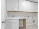 Bright laundry room with white cabinets and a built-in sink at 317 Highland Ridge Ln, Knightdale, NC 27545