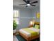 Bedroom staged with modern furniture, including a queen bed with natural light and backyard views at 352 Faucette Mill Rd, Hillsborough, NC 27278