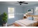 Bright bedroom with a ceiling fan, two windows and neutral paint colors at 352 Faucette Mill Rd, Hillsborough, NC 27278
