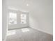 Sunlit bedroom with neutral carpet, two windows, and fresh white walls at 53 Lavender Ln, Clayton, NC 27520