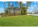Expansive backyard with lush lawn and mature trees, perfect for outdoor activities at 60 Bennett Rd, Coats, NC 27521