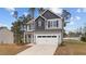 Charming two-story home featuring a two-car garage, landscaped yard, and inviting covered porch at 60 Bennett Rd, Coats, NC 27521