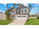 Charming two-story home with a well-manicured lawn, a two-car garage, and a mix of gray and light gray siding at 60 Bennett Rd, Coats, NC 27521