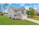 Well maintained two-story home with a two-car garage, landscaped front yard, and a mix of gray and light gray siding at 60 Bennett Rd, Coats, NC 27521