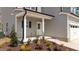 Inviting front entrance featuring a covered porch with white columns and fresh landscaping at 60 Bennett Rd, Coats, NC 27521