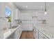 Well-lit kitchen showcasing white cabinets, granite countertops, a stainless steel sink, and subway tile backsplash at 60 Bennett Rd, Coats, NC 27521