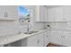 Bright kitchen featuring white cabinets, granite countertops, stainless steel sink, and subway tile backsplash at 60 Bennett Rd, Coats, NC 27521