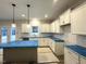 Well-lit kitchen with white cabinets, stylish pendant lights, and stainless steel appliances at 60 Bennett Rd, Coats, NC 27521